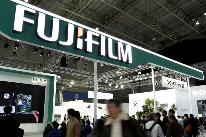 Attendees walk past the Fujifilm Holdings Corp. booth at the CP+ Camera and Photo Imaging Show in Yokohama, Kanagawa Prefecture, Japan.