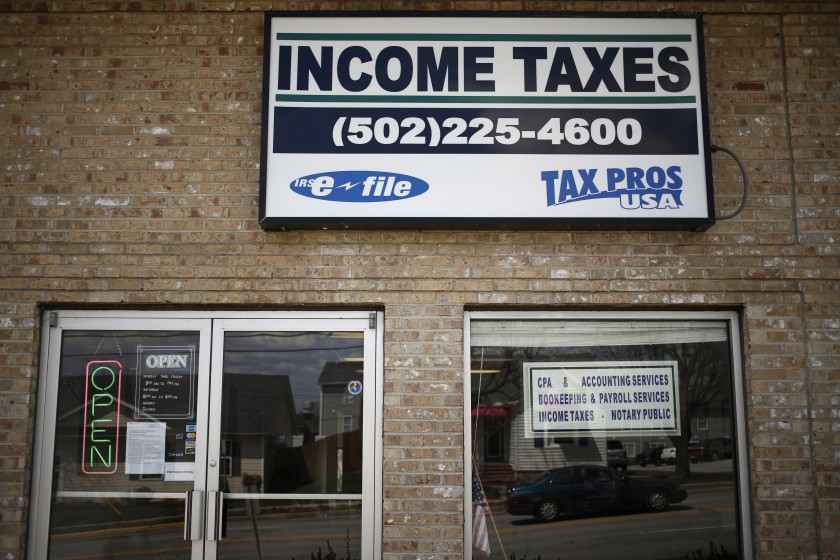Signage advertising income tax service is pictured in front of Tax Pros USA in La Grange, Kentucky, U.S., on Wednesday, April 9, 2014. The deadline for filing federal income tax returns to the Internal Revenue Service is Tuesday, April 15. Photographer: Luke Sharrett/Bloomberg