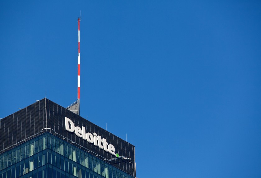 A logo sits above the head office of Deloitte LLP in Warsaw, Poland, on Monday, Jan. 9, 2017. Investors in Poland are betting that the nations central bank will raise its benchmark rate faster than stated. Photographer: Piotr Malecki/Bloomberg