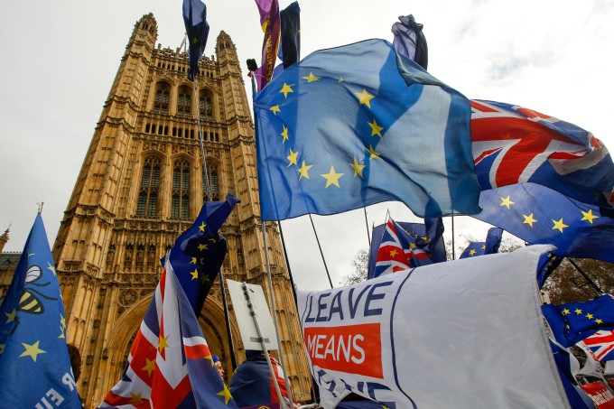 Anti and pro-Brexit demonstrators wave European Union (EU), British Union flags, also known as Union Jacks, and banners during protests outside the Houses of Parliament in London.