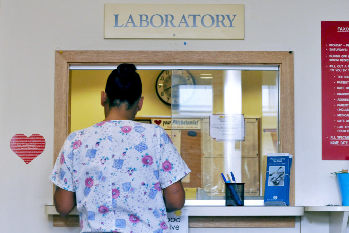 Nurse retrieves laboratory results from dispensing window at Falmouth Hospital, Falmouth, Mass.