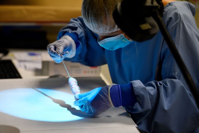 A technician uses a special lighting device called crimescope to search fingerprints on a knife on May 22, 2018 at Eurofins Forensic Analysis unit based in Nantes.  