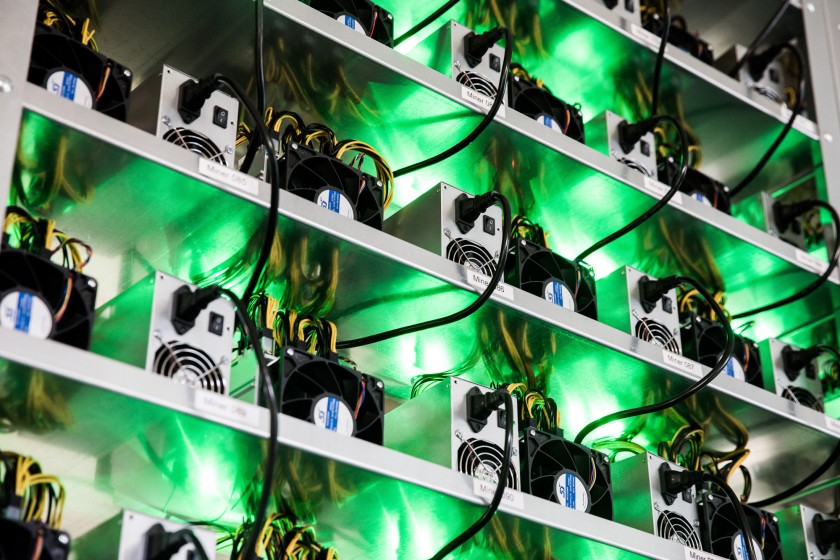 Cryptocurrency mining rigs composed of Antminer S9 ASIC machines operate on racks.