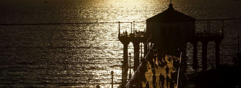 People walk on the pier at sunset in Manhattan Beach, California.