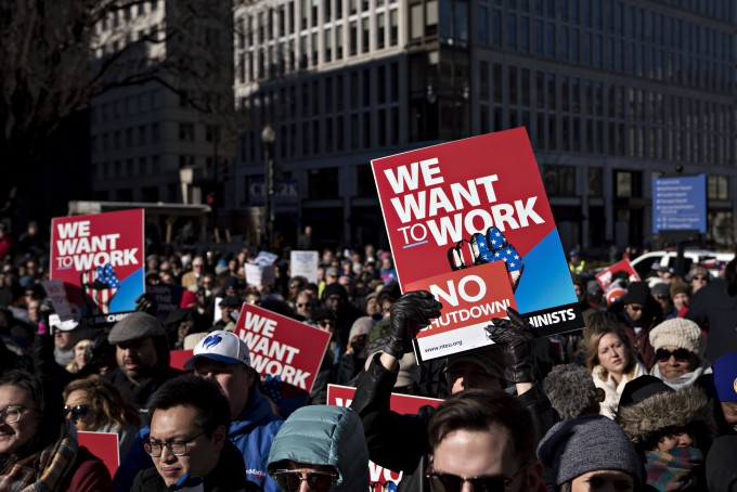 A demonstrator holds a We Want To Work sign during a rally with union members and federal employees to end the partial government shutdown outside the American Federation of Labor  Congress of Industrial Organizations (AFL-CIO) headquarters in Washington, D.C., U.S., on Thursday, Jan. 10, 2019. The partial government shutdown entered its 20th day today as its impact is more widely felt with about 800,000 federal workers who will miss their paychecks on Friday.